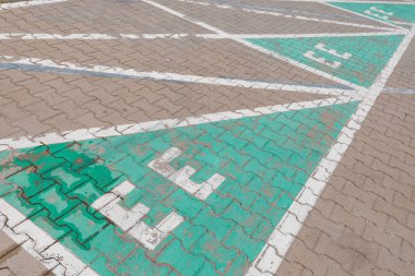 Sokakta elektrikli araba şarj oluyor. Otoparkta elektrikli araba tabelası. Çevre dostu enerji, şehirlerde daha az emisyon