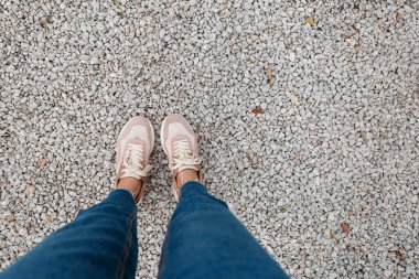Asfalt beton zeminde duran spor ayakkabıları. Dışarıda yürüyen ayaklı ayakkabılar. Genç Selphie hipster