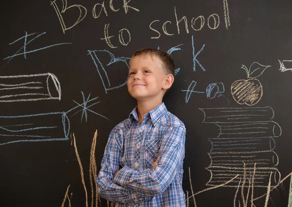 happy European boy at school Board with English inscription back to school