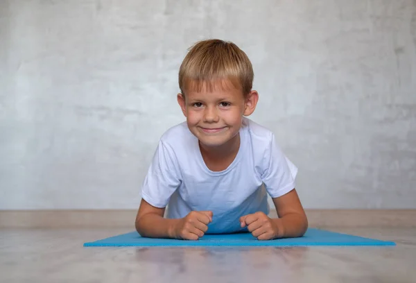 Европейский Мальчик Улыбкой Выполняет Упражнения Доске Гимнастике Мат — стоковое фото