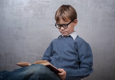 bir kitap okuma gözlüklü çocuk