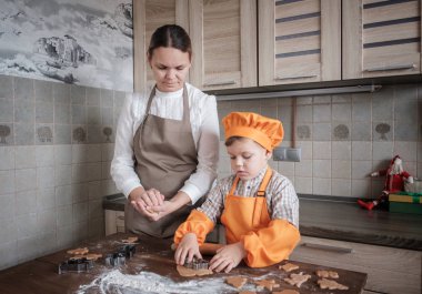 Anne ve oğlu Noel ve yeni yıl için mutfakta zencefilli kurabiye pişirin. geleneksel Avrupa aile