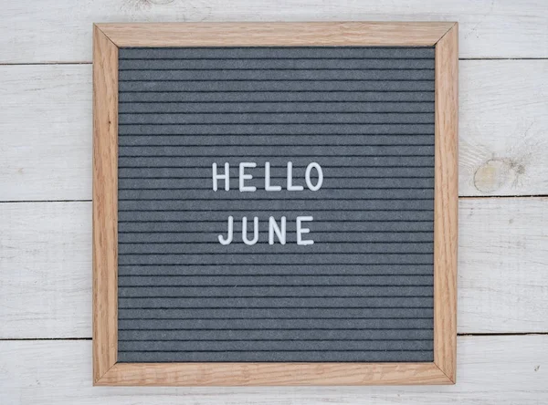 English text Hello June on a letter Board in white letters on a gray background