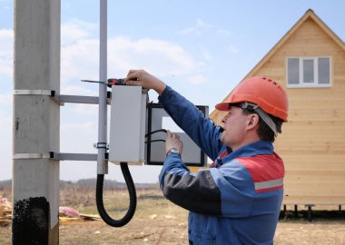 elektrikçi elektrik hatlarıdesteği elektrik sayacı kurulumu yapan. elektrikçi süreci. evin yan görünümü