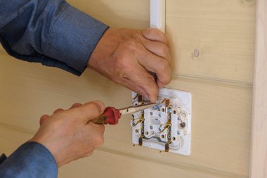 profesyonel elektrik mühendisi yeni bir ahşap evde elektrik prizleri ve kablolama kurulumu gerçekleştirir