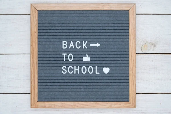 Texte anglais retour à l'école sur un feutre gris Conseil en lettres blanches et symboles comme, coeur et flèche — Photo