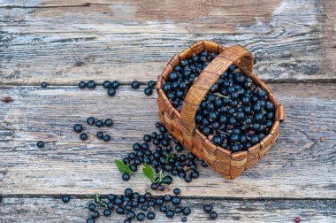 eski ahşap tahtalar üzerinde vintage hasır sepet taze toplenmiş frenk üzümü çilek