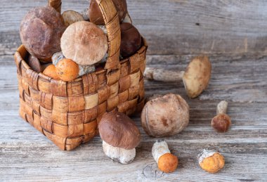 ahşap bir arka plan üzerinde güzel bir hasır sepet içinde orman mantar