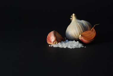 siyah bir arka plan üzerine kaba tuz ve sarımsak