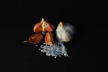 farklı çeşitleri ile siyah bir arka plan üzerine kaba tuz sarmısak