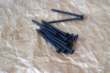 Kağıt arka plan üzerinde yalan vidalar