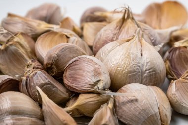 A close up shot of several garlic bulbs piled together, showing their natural texture and details