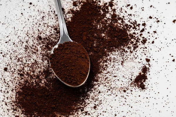 A spoon filled with soluble powdered coffee extract, isolated white background