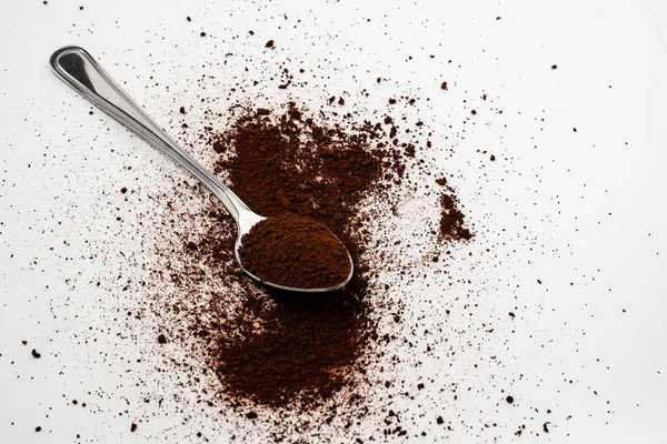 A spoon filled with soluble powdered coffee extract, isolated white background
