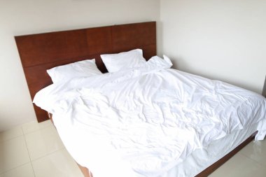 Hotel beyaz keten ile boş ahşap yatak.