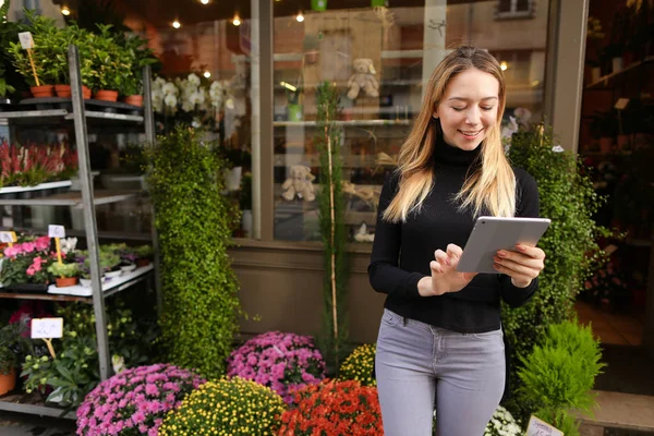 Çiçek Dükkanı duran Oda bitkiler yakınındaki tablet ile kadın genç Yöneticisi.