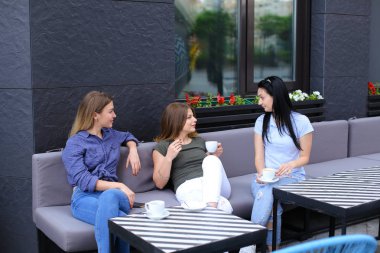 Café'de konuşan ve kahve içme mutlu ev kadınları.