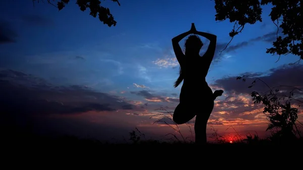 Shadow female silhouette in sunset background, woman doing yoga before sleeping.
