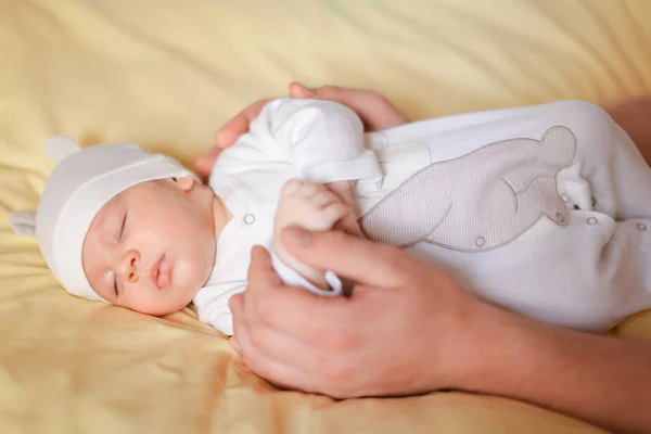 毛布、子を保持している大人の手横になっている白い帽子の素敵な赤ちゃん. — ストック写真