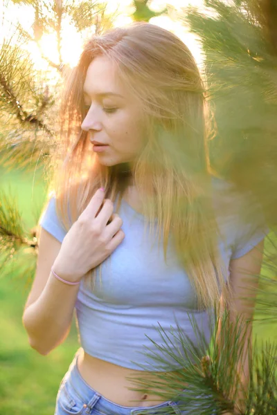 Bájos női fotó modell áll közel cédrusfa zöld parkban. — Stock Fotó