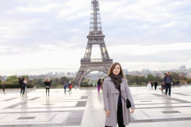 Gri ceket ayakta Eyfel Kulesi Paris yakınındaki genç kadın.