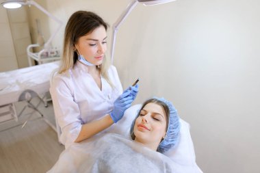 Güzel kadın makyaj güzellik uzmanı tarafından kaş dövme kalemi tarafından elde.