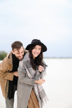 Gülümseyen kadın ve kat ve kış kar arka planda duran tulum giyen sakallı.
