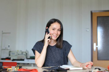 Konuşmak Smartphone tarafından deri atelier oturma ve el yapımı defter ve cüzdan, beyaz kadın kişi