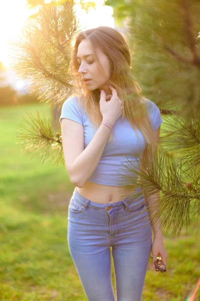 Hübsches Fotomodell in der Nähe von Zedernholz in grünem Gras Hintergrund. — Stockfoto