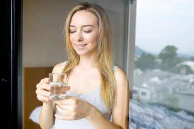 Genç çekici kadın kişi su sabah otelde içme..