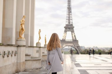 Kız Paris Eyfel Kulesi arka plan ile yaldızlı statues yakınındaki Trocadero meydanında yürüyüş.