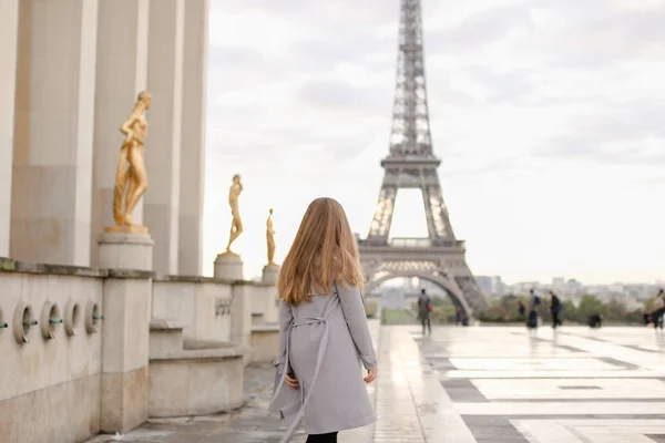 Meisje lopen op Trocadero plein in de buurt van vergulde beelden met achtergrond van de Eiffeltoren, Parijs. — Stockfoto