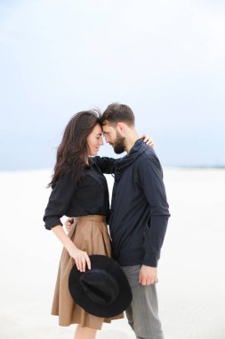 Beyaz Kış arka planda şapka tutarak, adam tutarak ve etek giyen oldukça çekici kadın.