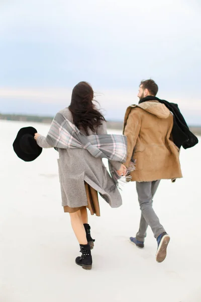 愉快的高加索夫妇走在冬天白色背景, 手和穿外套. — 图库照片