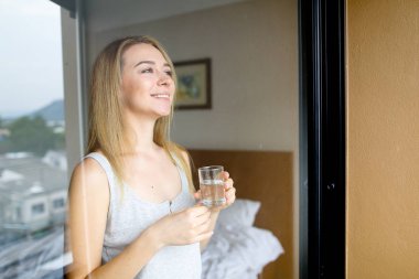 Genç kadın kişi içme bardak su sabah otelde güzel.