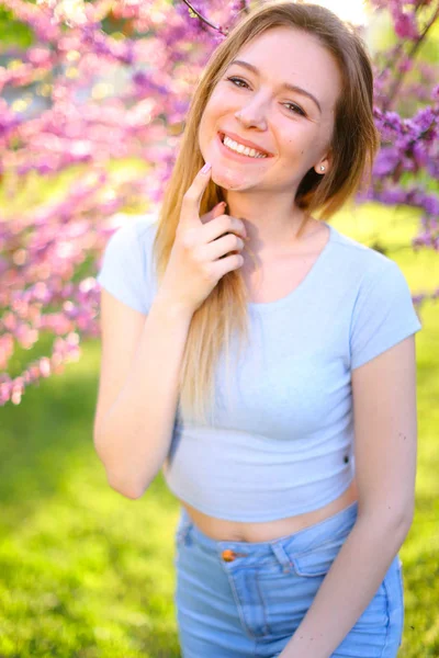Ung kvinnlig person med blommande träd bakgrund. — Stockfoto