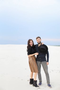 Etek ve siyah gömlek giyen kış kar tek sesli arka planda, sarılma genç çift.