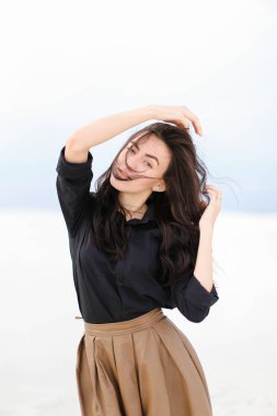 Siyah gömlek ve beyaz kış arka planda duran etek giyen kaldırdı elleriyle Genç beyaz kadın.