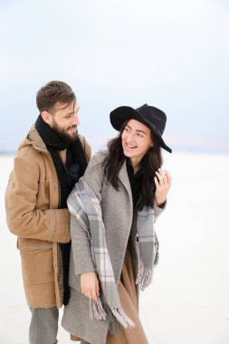 Gülümseyen genç kadın ve kat ve kış kar arka planda duran tulum giyen sakallı.
