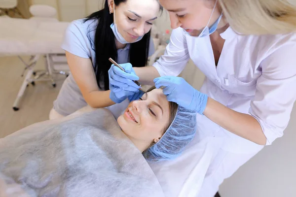 Cosmetologue et infirmière enlever les points noirs par le nettoyage manuel du visage pour la femme . — Photo