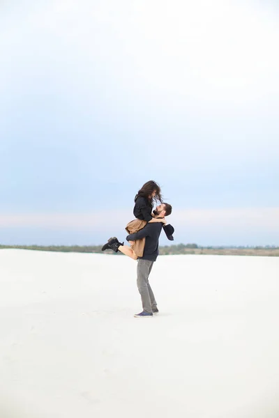 白い雪のバック グラウンドでのスカートを着て手女の子が拾っての若いアメリカの少年. — ストック写真