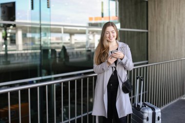 Sohbet ve smartphone valiz ve Havaalanı yakınında tarama işkadını.