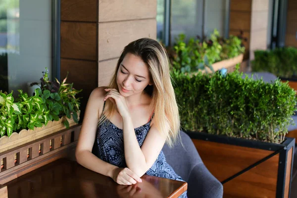 Frau sitzt im Café und ruht sich in der Nähe von Zimmerpflanzen aus. — Stockfoto