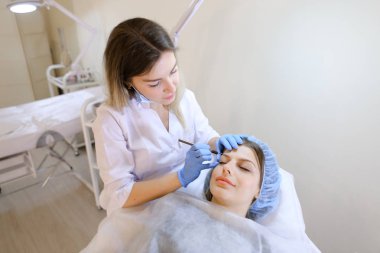 Sevimli kadın makyaj güzellik uzmanı tarafından kaş dövme kalemi tarafından elde.