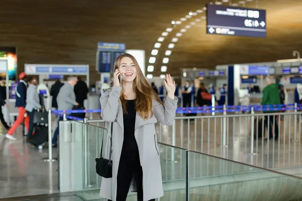 Osoba płci żeńskiej, mówienie przez smartfona i pozdrowienie przyjaciel ręce na lotnisko. — Zdjęcie stockowe
