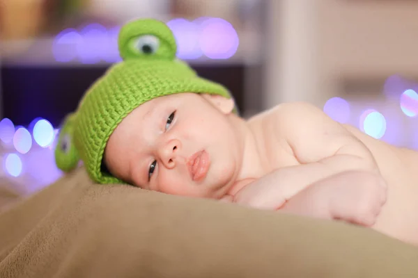 Pequeno Bebê Bonito Vestindo Boné Verde Deitado Fundo Reluzente Conceito — Fotografia de Stock