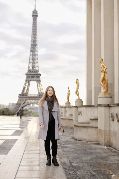 Young girl standing on Trocadero square near gilded statues and Eiffel Tower. — Stock Photo, Image