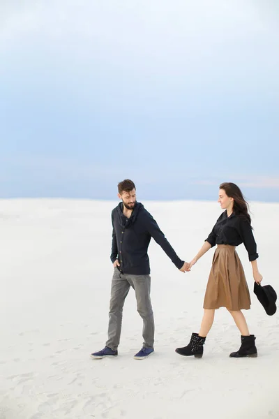 Casal caucasiano andando na neve e vestindo saia e jeans . — Fotografia de Stock