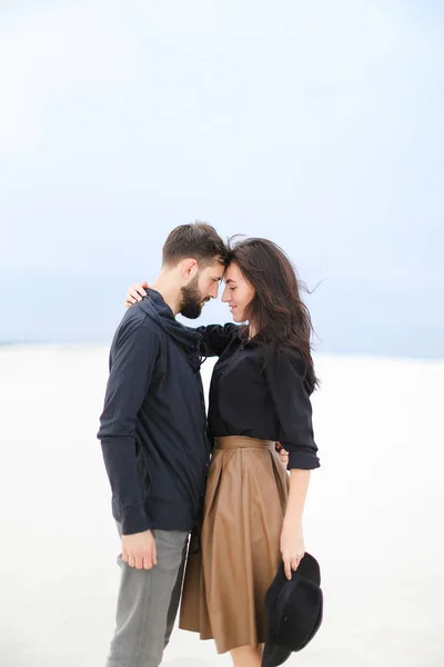 Mulher muito americana segurando homem e vestindo saia, mantendo chapéu em fundo de inverno branco . — Fotografia de Stock