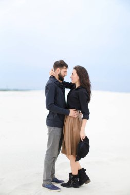 Etek, siyah bluz ve tutma şapka giyen adam kış kar arka planda sarılma beyaz güzel kadın.